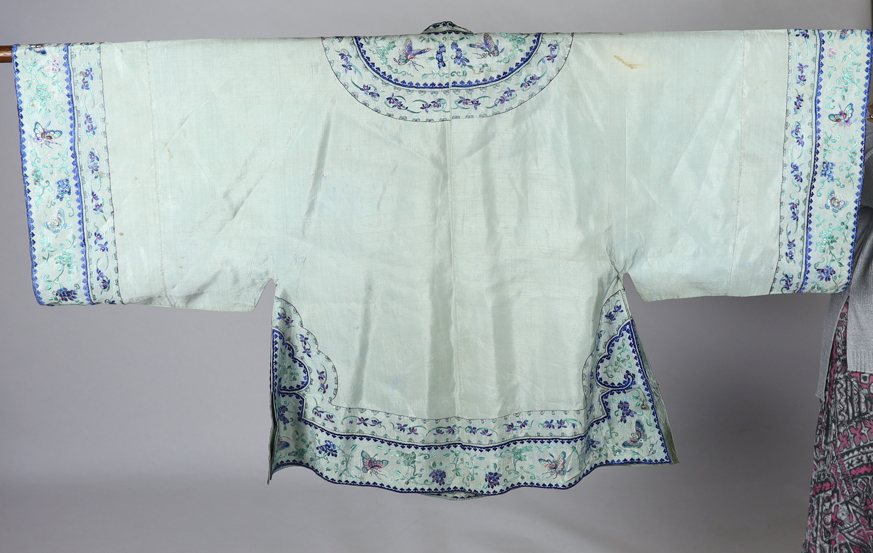 A 1930's Chinese silk embroidered robe, in pale turquoise silk with wide pastel embroidery of butterflies and flowers, 88cm long